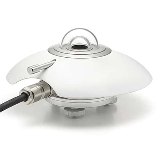 Bilden visar en pyranometer, ett instrument som används för att mäta global solinstrålning. Den har en skyddande kupol som gör det möjligt för sensorn att registrera både direkt och diffus solstrålning. Instrumentet är anslutet med en kabel för datainsamling och analys. Pyranometrar används ofta i meteorologiska stationer för att övervaka solenergi.