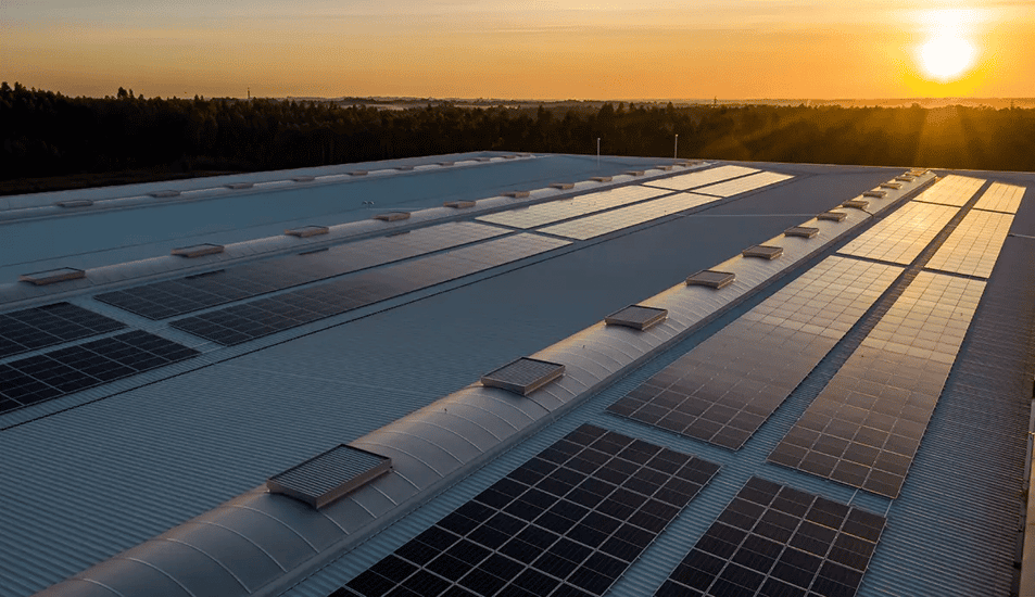 Alt text till bild: Solceller till företag monterade på industrihall.